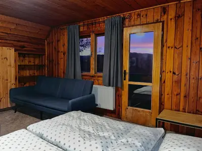 a bedroom with a bed and a couch and a window at Chata v Kamenném Přívozu in Kamenný Přívoz