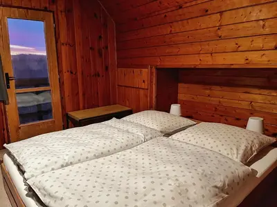 a bed in a wooden room with a window at Chata v Kamenném Přívozu in Kamenný Přívoz