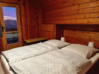 a bed in a wooden room with a window at Chata v Kamenném Přívozu in Kamenný Přívoz