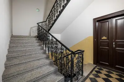 a staircase with black iron railings next to a door at Modern apartment in the center of Prague in Prague