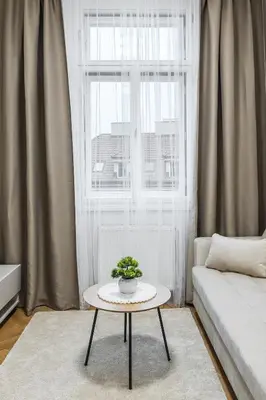 a living room with a table in front of a window at Modern apartment in the center of Prague in Prague
