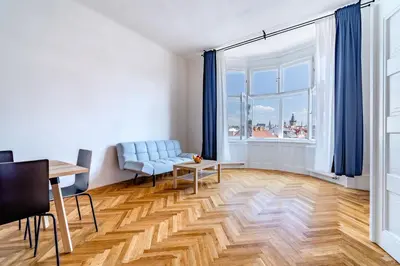 a living room with a blue couch and a table at Grand Old Town Suites in Prague