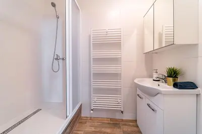 a white bathroom with a shower and a sink at Grand Old Town Suites in Prague