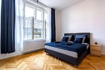 a bedroom with a bed and a large window at Grand Old Town Suites in Prague