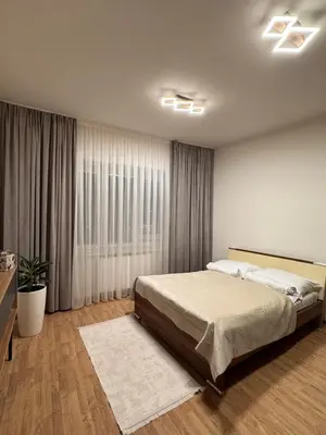 a bedroom with a bed and a large window at Apart & Studio metro Vysočanská in Prague