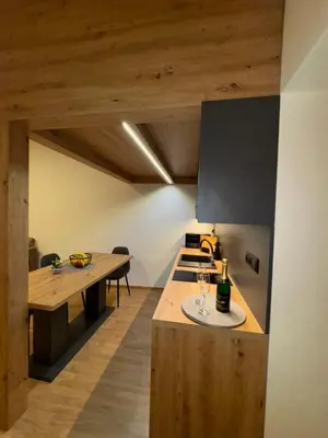 a kitchen with a wooden table with a bowl of fruit on it at Apart & Studio metro Vysočanská in Prague