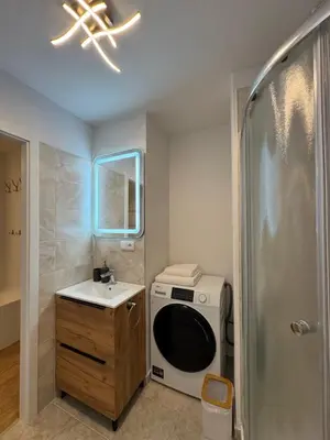 a bathroom with a sink and a washing machine at Apart & Studio metro Vysočanská in Prague