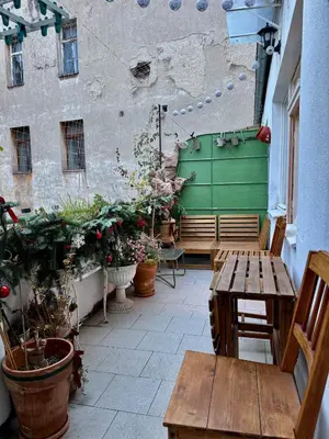 a patio with benches and potted plants and a green door at Cozy apartment with a terrace in the center of Prague in Prague