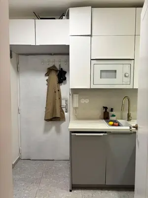 a kitchen with white cabinets and a sink and a microwave at Cozy apartment with a terrace in the center of Prague in Prague