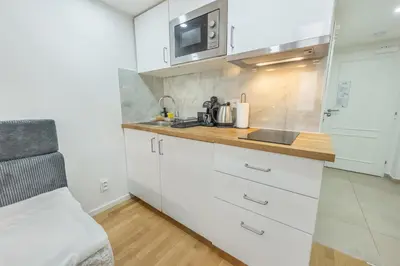a kitchen with white cabinets and a counter top at HOMELY I Central studio I ELEVATOR I SELF CHECK-IN in Prague