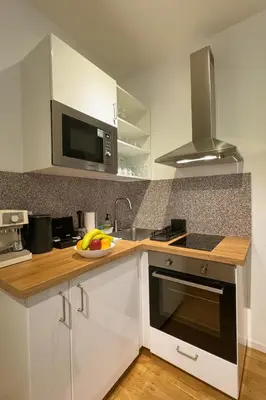 a kitchen with white cabinets and a sink and a microwave at HOMELY I Central 38m2 APT I ELEVATOR I Self Check-In in Prague
