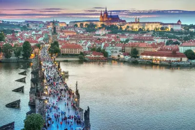 a group of people walking on a bridge over a river at Cozy Prague Navrátilová in Prague