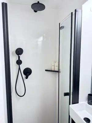a white bathroom with a shower and a sink at Old Town Green Room with private bathroom in Prague