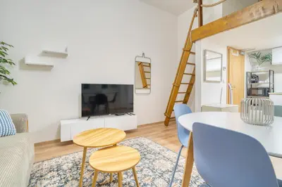 a living room with a table and chairs and a tv at Cozy Corner Sokolská by Rentez in Prague