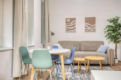 a living room with a couch and a table and chairs at Cozy Corner Sokolská by Rentez in Prague
