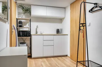 a kitchen with white cabinets and a sink at Cozy Corner Sokolská by Rentez in Prague