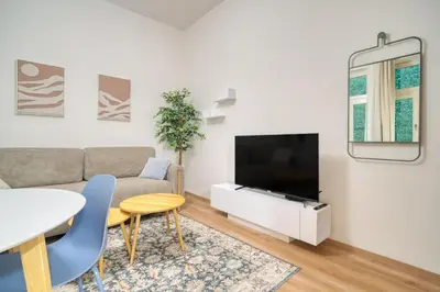 a living room with a couch and a tv at Cozy Corner Sokolská by Rentez in Prague