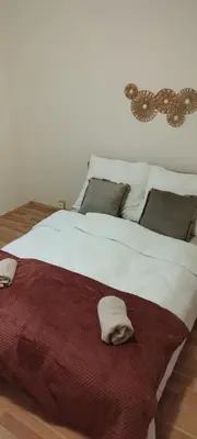a large white bed with two folded towels on it at Quiet Apartment Near Prosek Metro, Line C in Prague