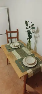 a wooden table with plates and glasses on it at Quiet Apartment Near Prosek Metro, Line C in Prague