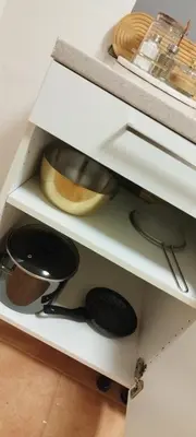 a kitchen shelf with pots and pans on it at Quiet Apartment Near Prosek Metro, Line C in Prague