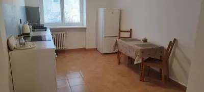 a small kitchen with a table and a refrigerator at Quiet Apartment Near Prosek Metro, Line C in Prague