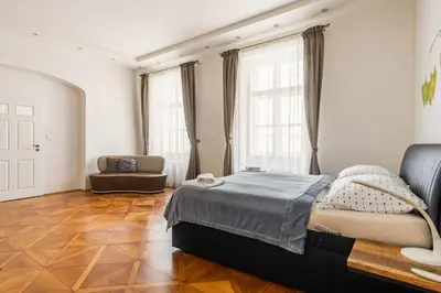 a bedroom with a large bed and a chair at Prague Centre Apartments in Prague