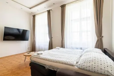 a bedroom with a bed and a flat screen tv at Prague Centre Apartments in Prague