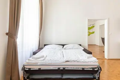 a bed in a room with white walls at Prague Centre Apartments in Prague
