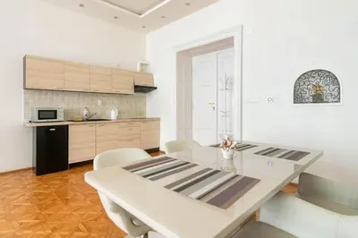 a white kitchen with a white table and chairs at Prague Centre Apartments in Prague