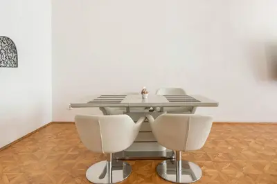 a dining room table with two chairs and a white wall at Prague Centre Apartments in Prague