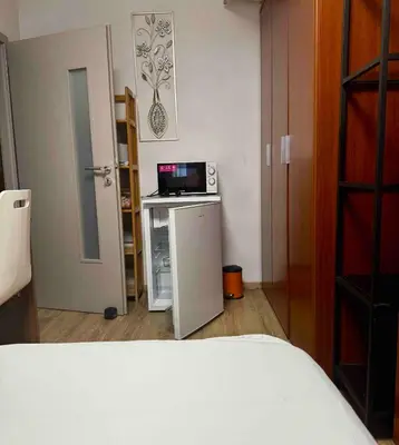 a bedroom with a small refrigerator and a microwave at 2-luzkovy pokoj Praha-13 metro HURKA in Prague