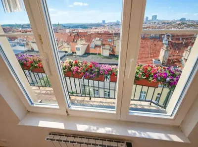 a living room with a table and a kitchen at Skyline Terrace Flat in Prague