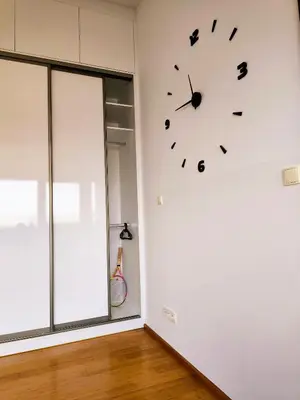 a clock on a white wall in a room at Lucky 55 in Prague