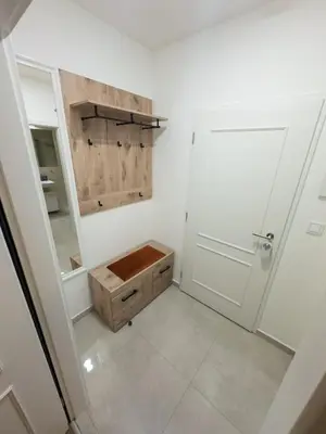 a small bathroom with a wooden box and a door at florenc apartments prague by kalab in Prague