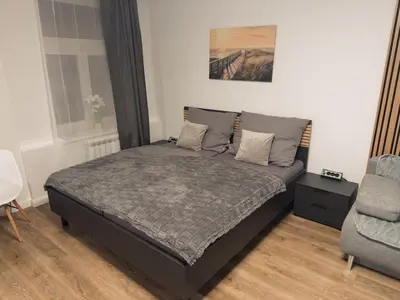 a bedroom with a bed and a chair in it at florenc apartments prague by kalab in Prague