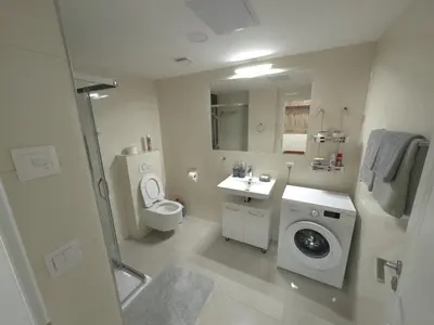 a bathroom with a washing machine and a sink at florenc apartments prague by kalab in Prague