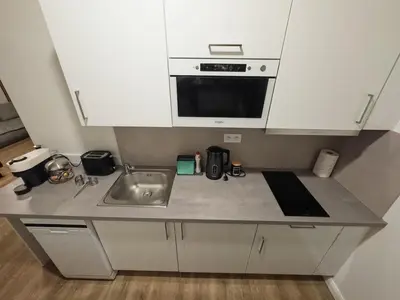 a kitchen counter with a sink and a microwave at florenc apartments prague by kalab in Prague