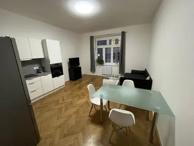a kitchen and living room with a table and chairs at Simple and Cozy in Prague