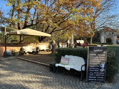 a park with a bench and an umbrella and a sign at Simple and Cozy in Prague