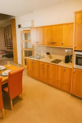 a large kitchen with wooden cabinets and a table at Maisonette apartment in the center of Prague - Samcova in Prague