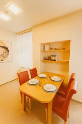 a dining room with a wooden table and orange chairs at Maisonette apartment in the center of Prague - Samcova in Prague