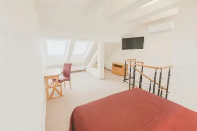 a bedroom with a bed and a desk and a tv at Maisonette apartment in the center of Prague - Samcova in Prague