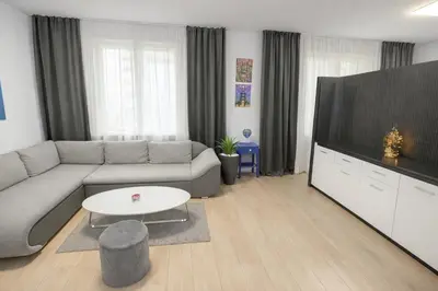 a living room with a couch and a large television at Exclusive Apartment with Terrace, View & Jacuzzi in Prague