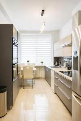 a kitchen with stainless steel appliances and a table at Exclusive Apartment with Terrace, View & Jacuzzi in Prague