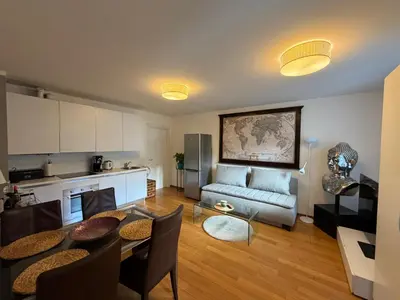 a kitchen and living room with a table and a couch at Riverside Grande in Prague