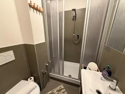 a bathroom with a shower and a toilet and a sink at Riverside Grande in Prague