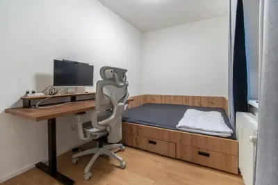a bedroom with a bed and a desk with a computer at Prague Family Apartment in Prague