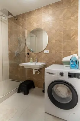 a bathroom with a washing machine and a sink at Prague Family Apartment in Prague