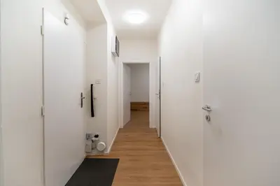 a hallway with white walls and wooden floors at Prague Family Apartment in Prague