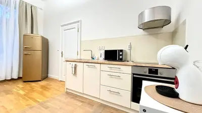 a kitchen with white cabinets and a refrigerator at Night next to the Museum in Prague